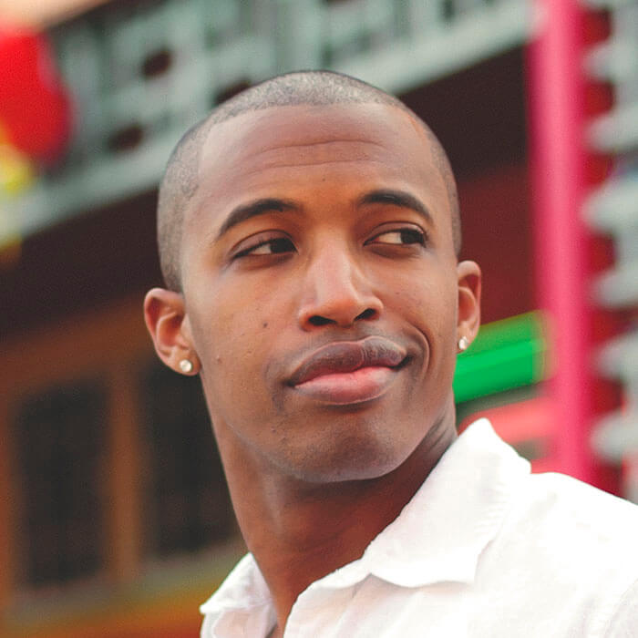 Man smirking in a white shirt