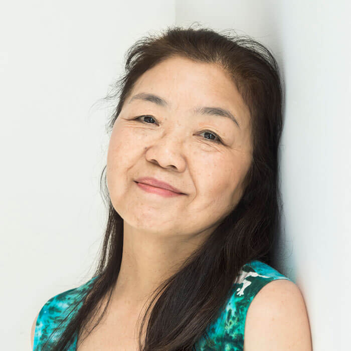 Woman in green shirt leaning against the wall