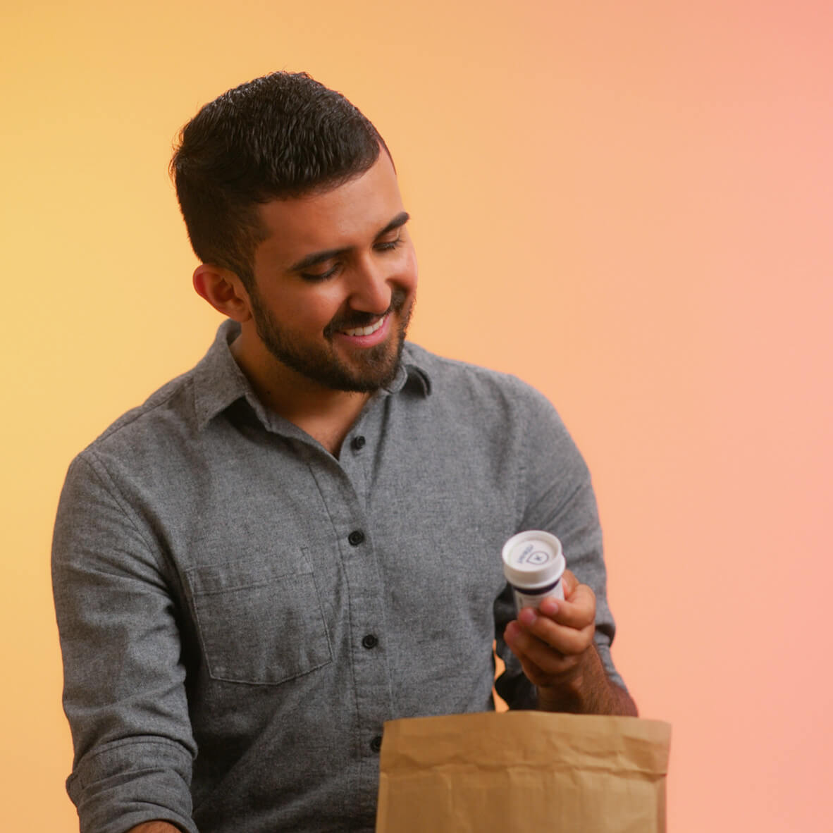 Man opening a package containing a bottle of medication