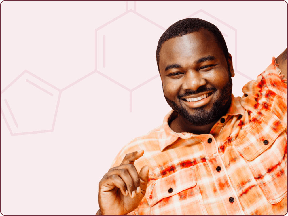 Man in a bright orange shirt smiling with his arm raised