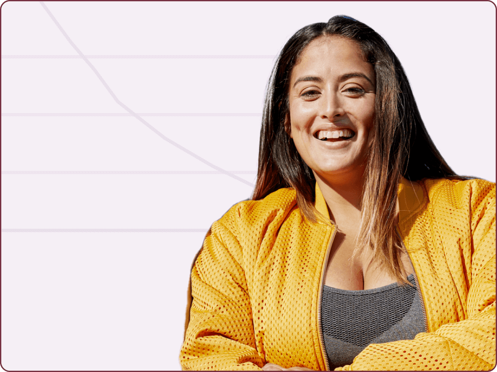 Woman in a yellow jacket smiling with her arms crossed
